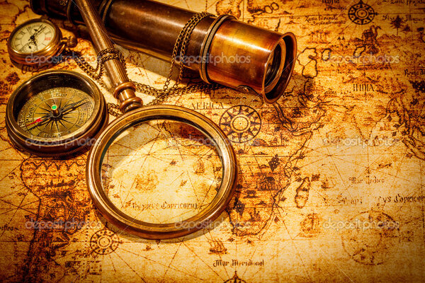 Vintage magnifying glass lies on an ancient world map