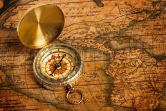Old vintage golden compass On ancient Map